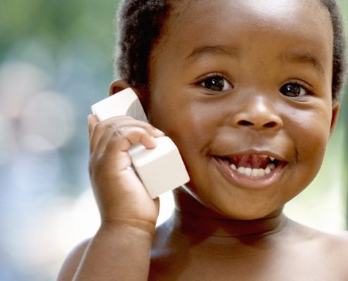 a toddler on the phone smiling