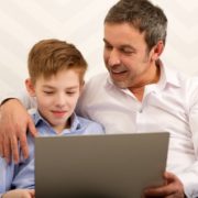 father and son who has expressive language disorder on a laptop