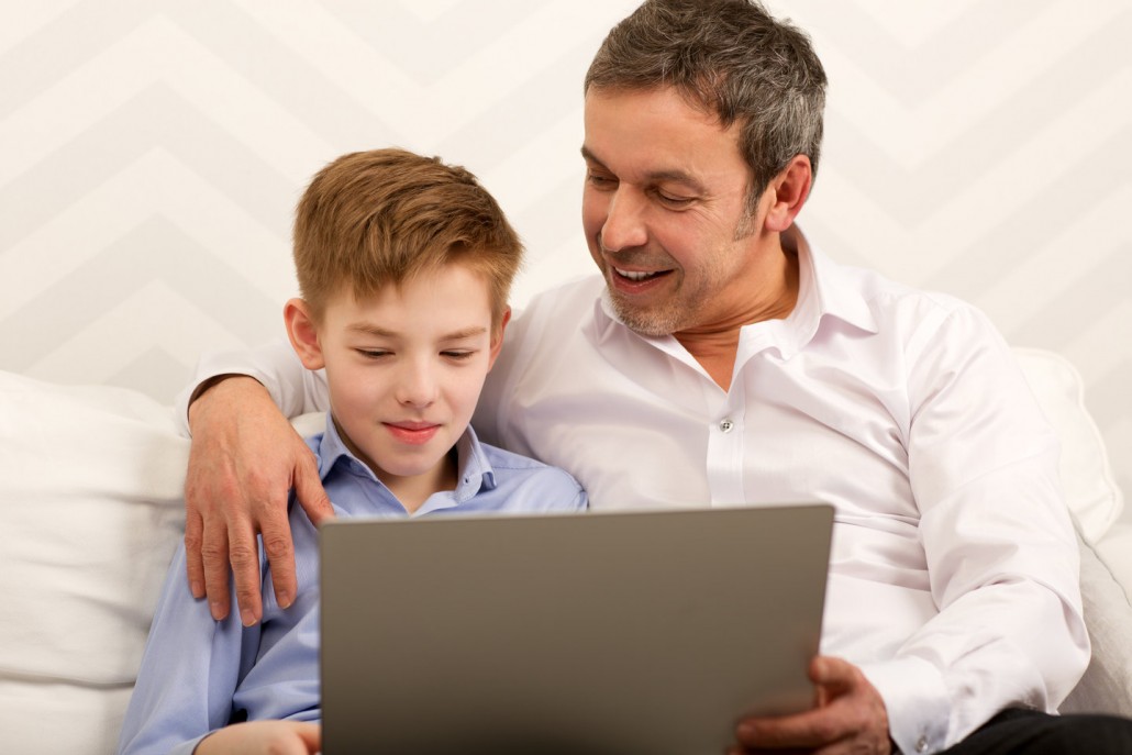 father and son who has expressive language disorder on a laptop