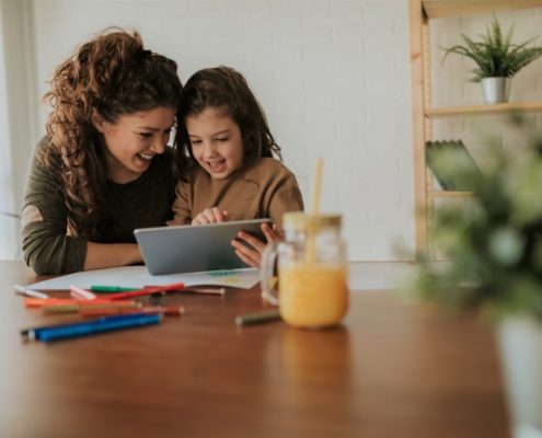 child with a parent learning at home during the pandemic