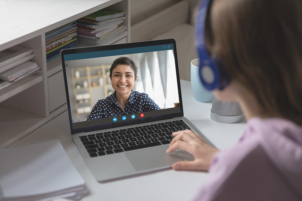 Girl talking to speech therapist on laptop representing Great Speech experts in online speech therapy