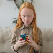 a child playing with a rubik's cube to help promote her speech therapy at home