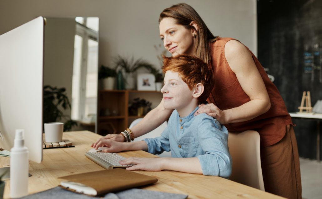 a parent helping their child learn at home online during the pandemic