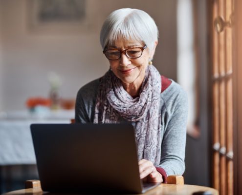 a woman on a laptop with Parkinson's Disase