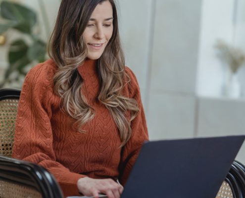 a woman researching the difference between a stutter and stammer from her laptop at home