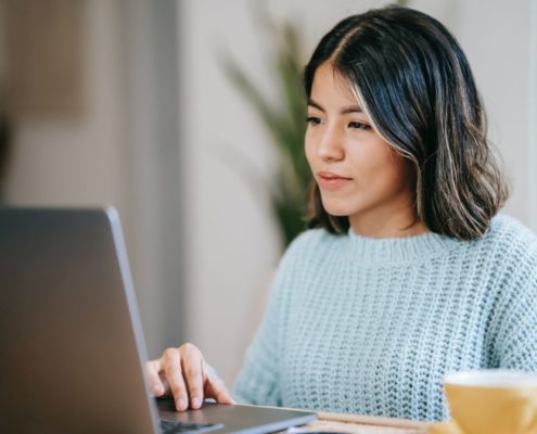 woman with Orofacial-Myofunctional-Disorder on her laptop at home