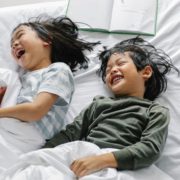 A boy and girl at home laughing and speaking to each other