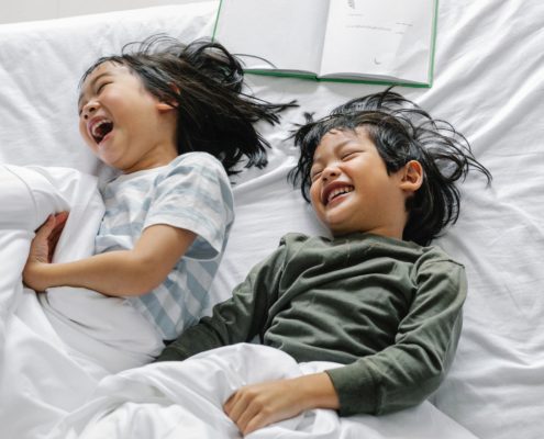 A boy and girl at home laughing and speaking to each other