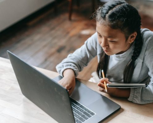 a girl practicing her reading at home on her computer