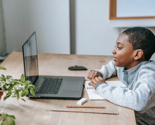 a 5 year old child at a laptop learning at home
