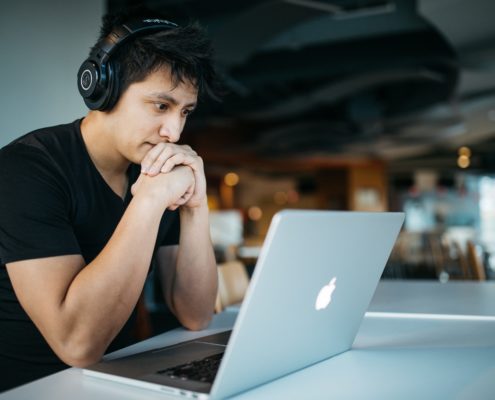 an adult on his laptop doing online speech therapy