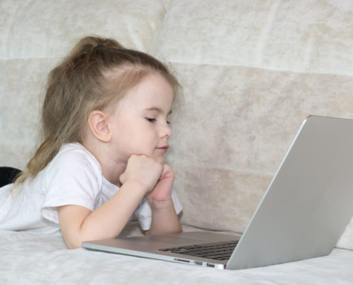 A child at home on a laptop doing articulation therapy from home