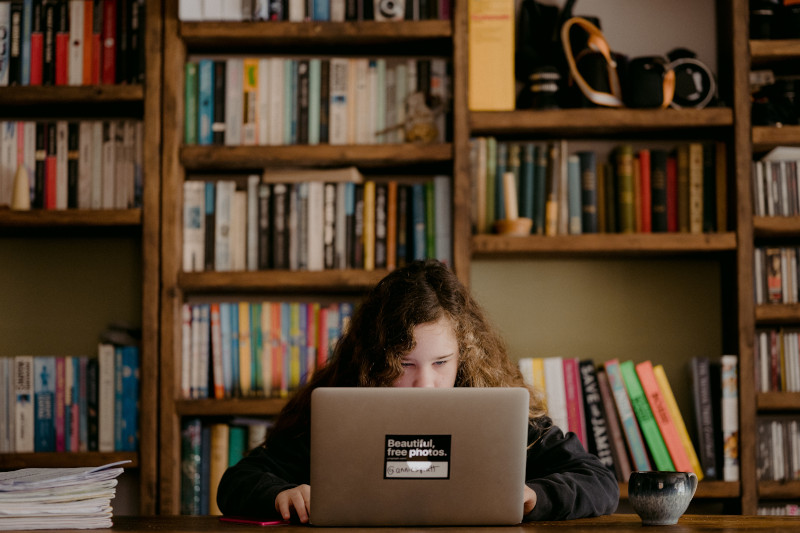 a child with autism researching at home on a laptop