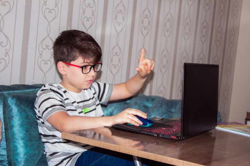 a child at home doing online speech therapy