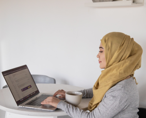 a woman at home getting voice therapy from her laptop