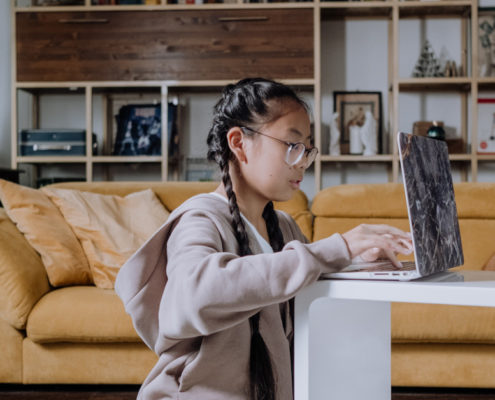 a girls at home working on her speech via a laptop
