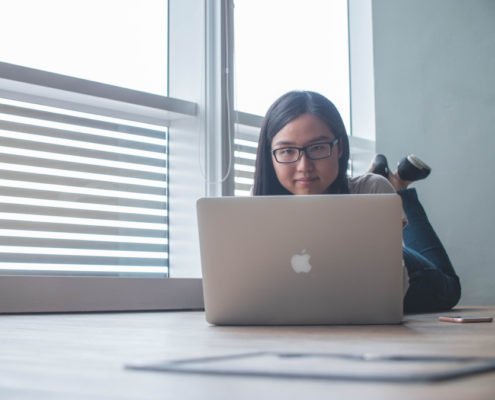 a woman at home on her laptop doing voice therapy