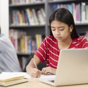 Female High School Student Working At Laptop In Library representing Benefit from Speech and Language Therapy