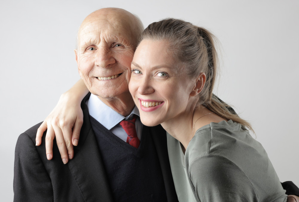 a woman with her arm over an elderly man