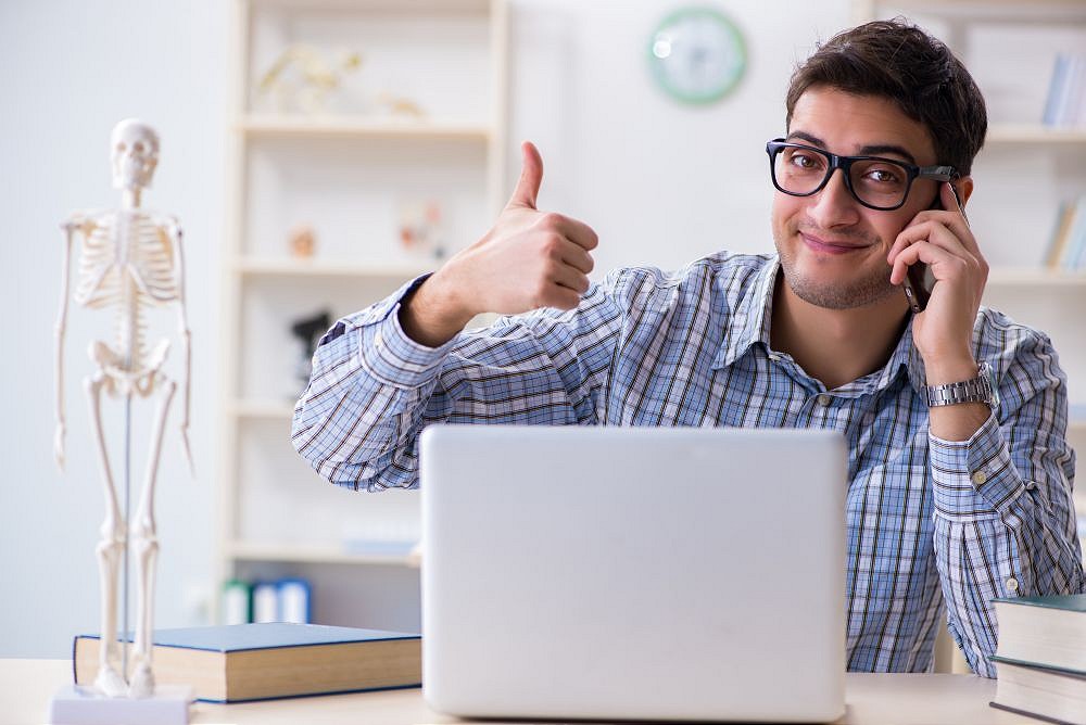 man with his thumbs up on a laptop