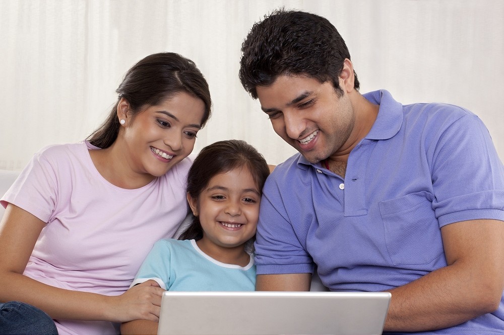 parents with their child on a laptop at home