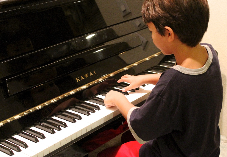 a boy playing a piano to aid his speech therapy