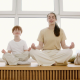 two people meditating on a wooden surface