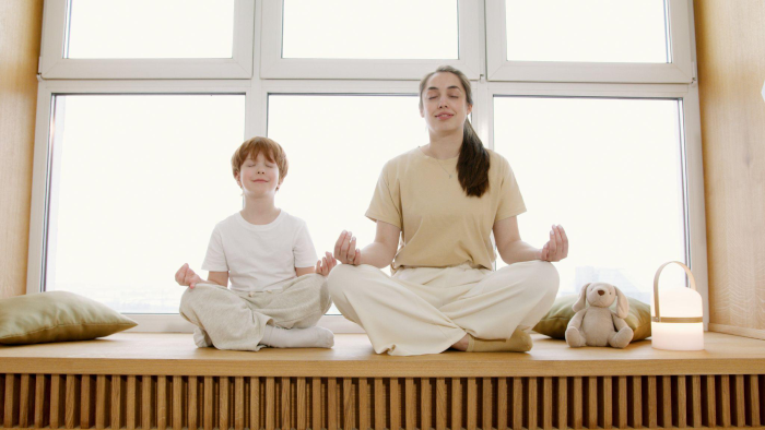 two people meditating on a wooden surface