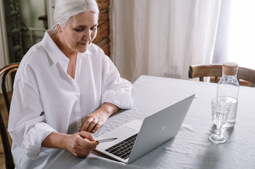 an elderly woman on her laptop working on her language difficulties