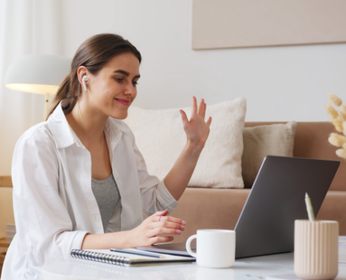 a woman taking a deep breath on her laptop at home