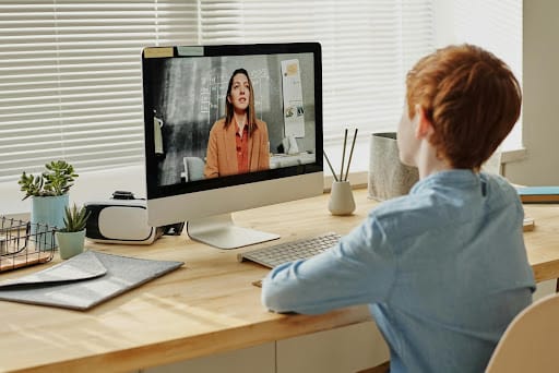 a boy at home with a functional speech disorder learning from home on his laptop