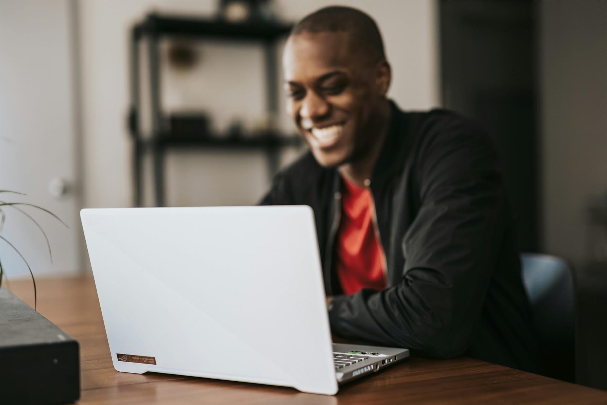 Man smiling while working on a laptop